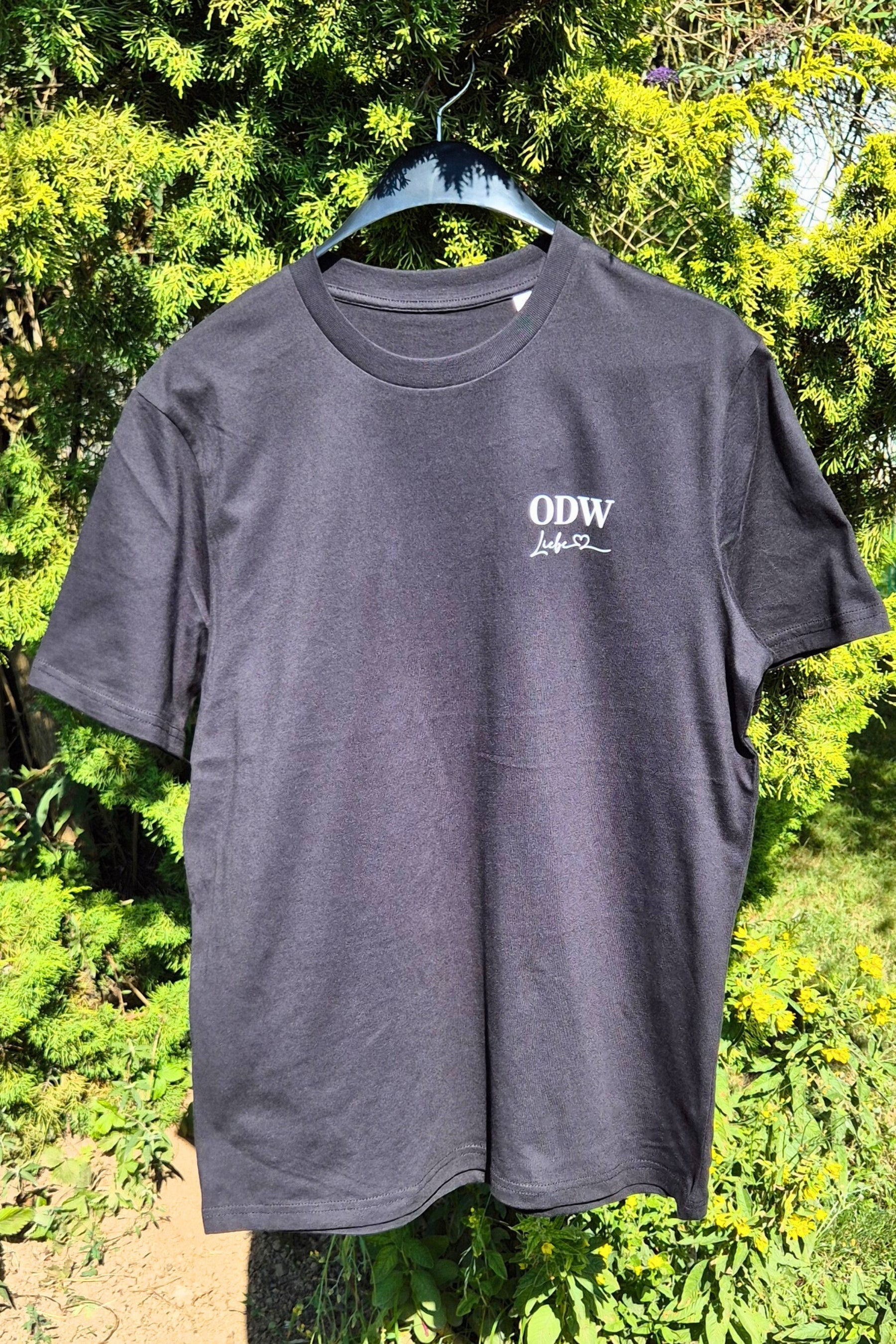 Ein ODWLiebe Motiv auf der linken Brust eines schwarzen Herren Tshirts
