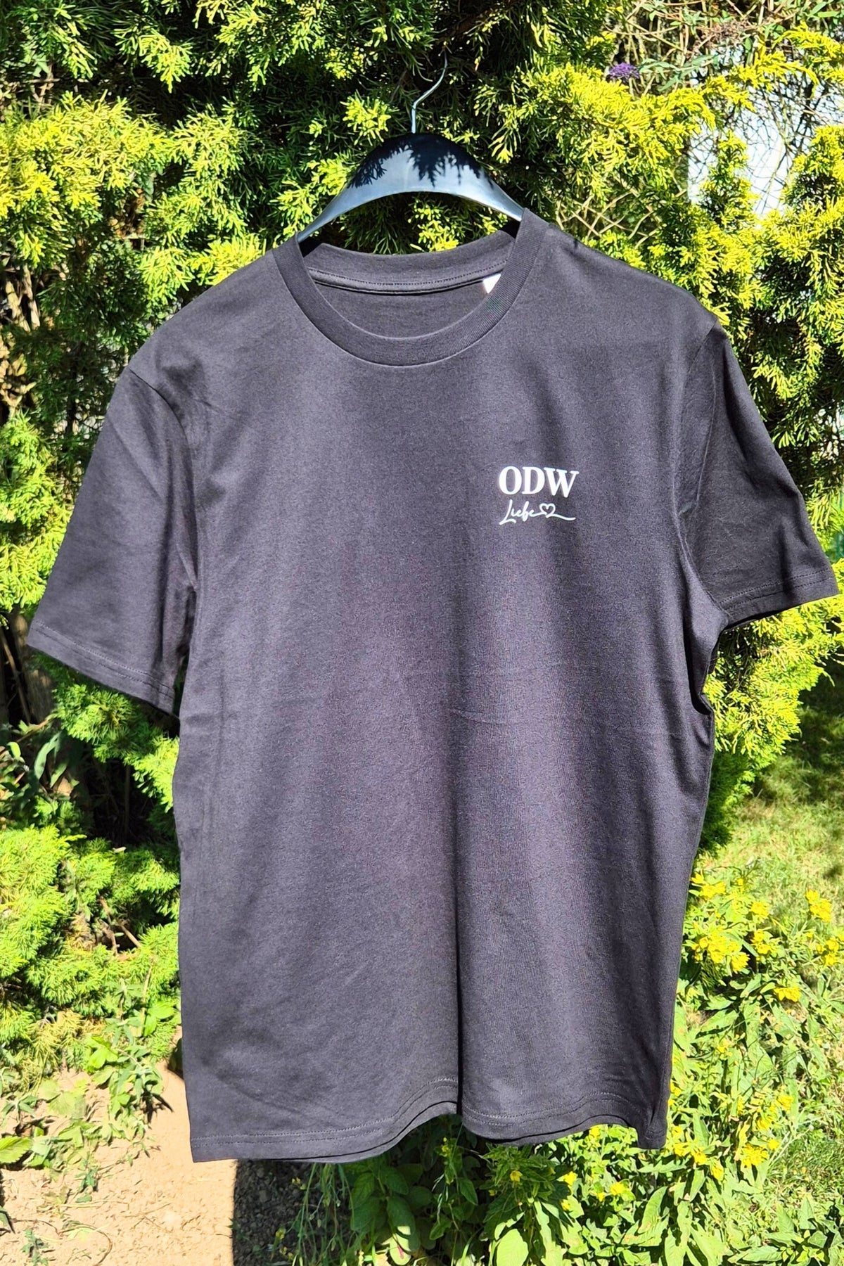 Ein ODWLiebe Motiv auf der linken Brust eines schwarzen Herren Tshirts